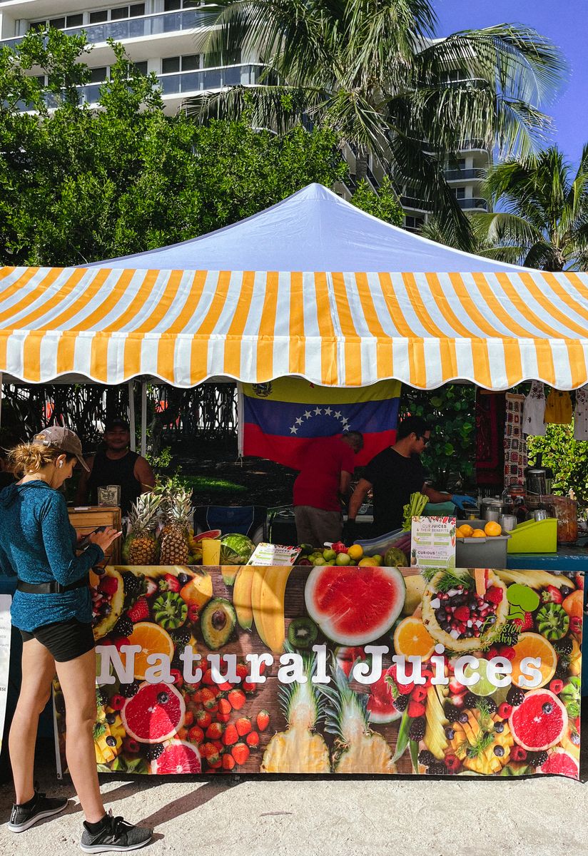 Natural juice stand under a striped canopy